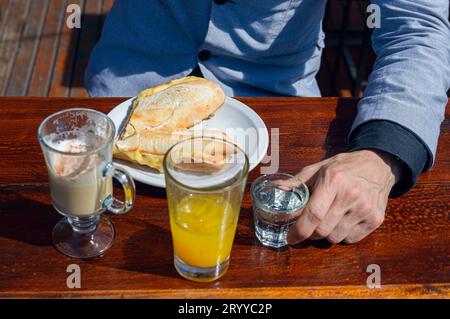Aus nächster Nähe und Blick auf das Kaffee-Frühstück mit Orangensaft, Schinken und Käse-Sandwich, serviert auf dem Tisch vor dem Restaurant mit nicht erkennbaren Caucas Stockfoto