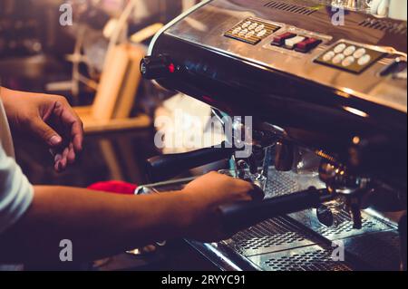 Nahaufnahme eines professionellen männlichen Barista, der eine Tasse Kaffee mit Kaffeemaschine im Restaurant oder Café zubereitete. Personen und Stockfoto