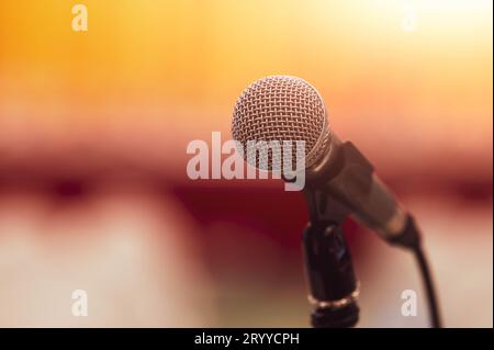 Nahaufnahme des Mikrofons auf abstrakter verschwommener Hintergrundrede im Seminarsaal und Licht als Gast und Konferenz sp Stockfoto