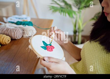 Stanznadel. Asiatische Frau, die handgemachtes Hobby-Stricken in der Atelierwerkstatt herstellt. Designer-Arbeitsplatz Handgefertigtes Bastelprojekt DIY Embro Stockfoto