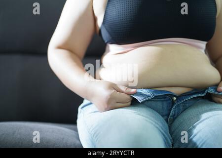 Fettleibige Frau mit fettleibigem Bauch. Übergewichtige Frau, die seinen fetten Bauch berührt und abnehmen will. Fette Frau mit oberschenkel Stockfoto