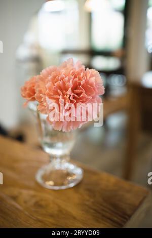 Wohnzimmerdekoration getrocknete Blumen in Glasvase in Wohnzimmerdekoration. Rustikaler brauner Holztisch, Restaurant, Café-Inneneinrichtung Stockfoto