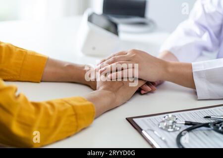 Arzt im Gesundheitswesen. Berufsarzt im weißen Uniform-Mantel Interview mit dem Patienten, der seine männliche Patie beruhigt Stockfoto