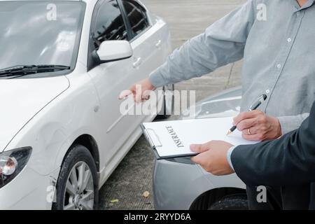 Schadenregulierer, Der Ein Beschädigtes Fahrzeug Inspiziert. Verkaufsleiter, der das Formular für den Antrag auf Beratung unter Berücksichtigung von Hypotheken ausgibt Stockfoto