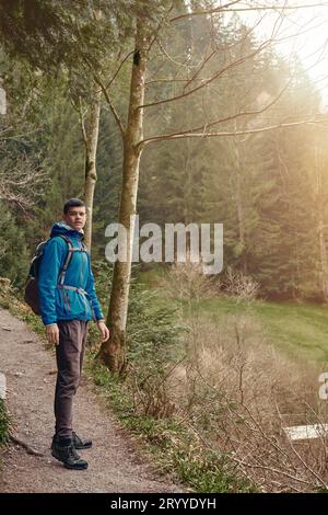 Ein Tourist mit Rucksack steht auf einem Bergweg und blickt in die Ferne. Das Konzept von Reise und Abenteuer. Trave Stockfoto