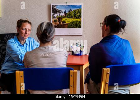 Bad Kreuznach, Deutschland. 30. August 2023. Alexandra Böning (links), Direktorin des Frauenheims Bad Kreuznach, spricht mit zwei Frauen. Für die Betroffenen ist es oft schwierig, in ein Frauenhaus zu gehen. Aber auch jenseits ihrer eigenen Gefühle sind die Hürden hoch: Nur selten ist auch ein Platz frei. (Zu dpa 'Life in a Women's Shelter: 'People Who Get Back to me') Credit: Andreas Arnold/dpa/Alamy Live News Stockfoto