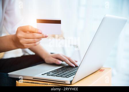 Frau hält eine Kreditkarte für Online-Shopping oder die Bestellung von Produkten über das Internet, wenn sie einen Laptop verwendet. Geschäft und Zahlung Co Stockfoto