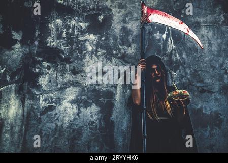 Daemon Hexe mit reaper auf grunge Wand Hintergrund. Halloween und religiöses Konzept. Daemon Engel und Satan Thema. Stockfoto