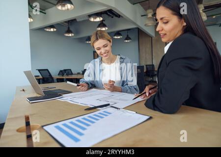 Zwei Kollegen besprechen das Projekt, bevor sie dem Teamleiter im Büro eine Präsentation zeigen Stockfoto