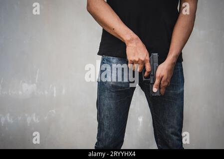 Räuber, der eine Waffe hält, um Mordbereitschaft zu haben, stiehlt Geld in einem verlassenen Gebäude. Selektiver Fokus. Kriminalität und soziale Fragen verbergen sich Stockfoto