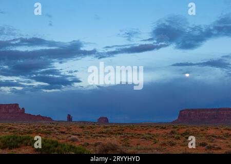 Monument Valley in Utah im Mondschein. Sonnenuntergang im Monument Valley mit Mond am Himmel Stockfoto