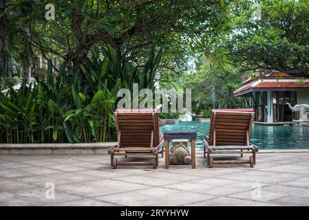 Wunderschöne Liegestühle in der Nähe des Swimmingpools. Urlaubs- und Entspannungskonzept. Lifestyles und Innendesign. Sommer und Frühling Stockfoto