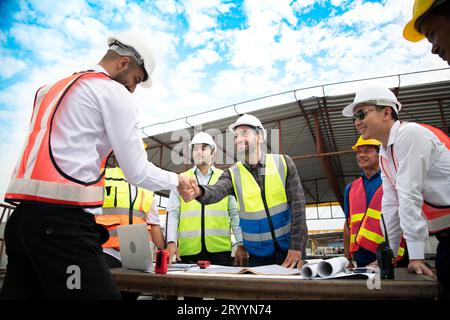 Bauingenieure, Architekten und Vorarbeiter bilden eine Gruppe. Nehmen Sie an einer Besprechung Teil, um neue Bauprojekte zu planen. Schütteln Stockfoto