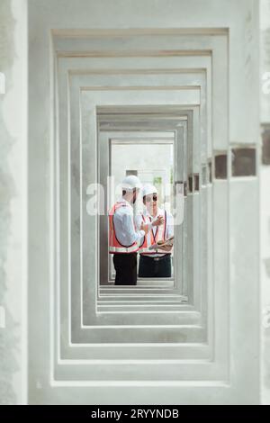 Beide Bauingenieure überprüfen die Qualität der gefertigten Betonfertigwandplatten. Auch zur Überwachung der signifikanten Konstruktion Stockfoto