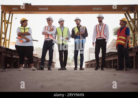 Eine Gruppe von Architekten, Baumeistern und Bauingenieuren überprüft die Arbeit und spricht darüber, wie das Projekt im Konsens aussieht Stockfoto