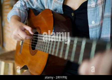 Glückliche junge Frau Hände, die Akustikgitarrenmusiker Â allein spielen, komponieren instrumentale Lektion songÂ Gitarrenspiel Stockfoto