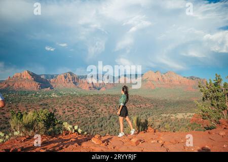 Junge Wanderer am Rande einer Klippe am Cathedral Rock in Sedona, Arizona. Blick vom szenischen Cathedral Rock in Sedona mit bl Stockfoto