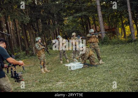 Modern Warfare Soldiers Squad verwenden Drohne für Scouting und Überwachung während der militärischen Operation im Wald. Stockfoto