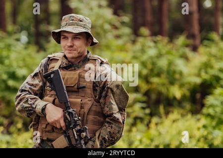 Ein moderner Kriegssoldat im Kriegsdienst in dichten und gefährlichen Waldgebieten. Gefährliche militärische Rettungseinsätze Stockfoto