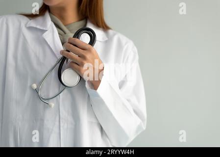 Die Ärztin hält ein Stethoskop und hört Herzschläge auf weißem Hintergrund. Medizin und Gesundheitskonzept. Krankenhaus und Stockfoto