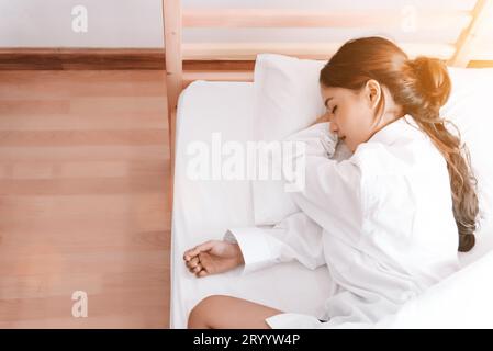 Junge asiatische Frau, die morgens auf weißem Bett schläft. Schönheits- und Urlaubskonzept. Urlaubs- und Relaxthema. Innenraum und Peopl Stockfoto