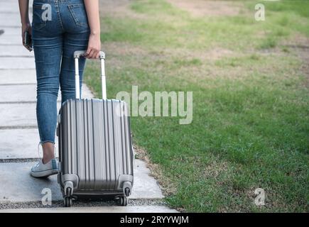 Reisende Frau, die Gepäck trägt. Touristische Spaziergänge mit Koffern Travel Lifestyle Konzept. Stockfoto