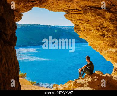 Gozo Island Malta, junger Mann und Blick auf die Ramla Bay, von der Tal Mixta Cave Gozo Stockfoto