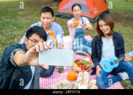 Eine glückliche Gruppe lächelnder Freunde macht ein Selfie-Porträt im Wald im Zelt. Stockfoto