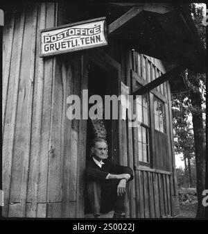 Gruetli, Tennessee, USA. Um 1938. Menschen; Eine Frau und ein Mann in einer Holzhütte mit dem Schild "Post Gruetli. Tenn.' hängt daran. Archivfoto in den 1930er Jahren von Annemarie Schwarzenbach von Depression America Stockfoto