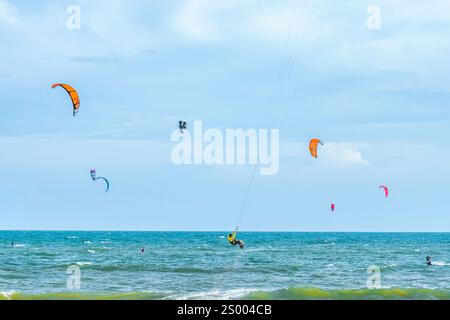 Kitesurfen. Viele Silhouetten von Drachen am Himmel der Mui ne Bucht und führen alle Arten von Stunts. Das Konzept von Sport, Gesundheit, Erholung. Feiertage Stockfoto