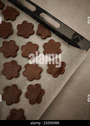 Plätzchen in Form von Schokoladenblumen, die auf einem Tablett backen, weihnachten, Kopierraum Stockfoto