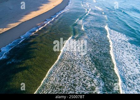Drohnenblick auf einen nicht überfüllten Strand in der Morgensonne Stockfoto