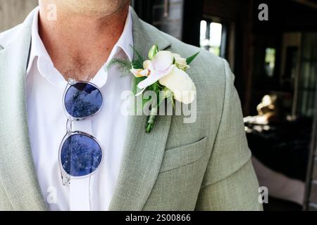 mans Blumennadel und Sonnenbrille bereit für eine Hochzeitsfeier Stockfoto