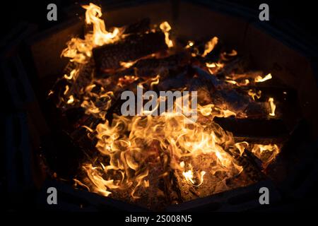 Großes Lagerfeuer in der Nacht. Brennholz brennt unter freiem Himmel. Stockfoto