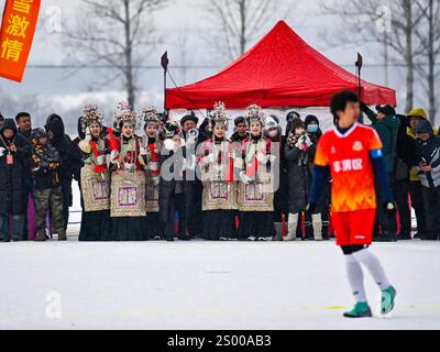 (241223) -- JILIN, 23. Dezember 2024 (Xinhua) -- Künstler aus dem County Rongjiang, Provinz Guizhou im Südwesten Chinas, jubeln das Team während eines Freundschaftsspiels zwischen dem Fußballteam des Bezirks Fengman und dem Fußballteam der „Village Super League“ des Bezirks Rongjiang, das am 23. Dezember 2024 auf dem Snowfield im Dorf Nanyang im Dorf Shulan, nordöstlich Chinas Provinz Jilin stattfand. das Fußballteam der „Village Super League“ des Bezirks Rongjiang reiste etwa 3000 km von Westchina nach Nordostchina, um gegen das örn zu spielen. Jilin City's Fengman District Football Te Stockfoto