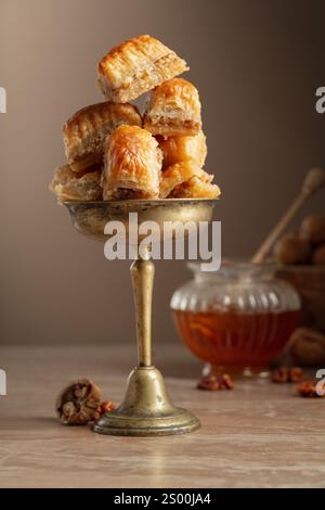 Baklava mit Walnüssen und Honig auf beigefarbenem Hintergrund. Traditionelle östliche Wüste. Stockfoto