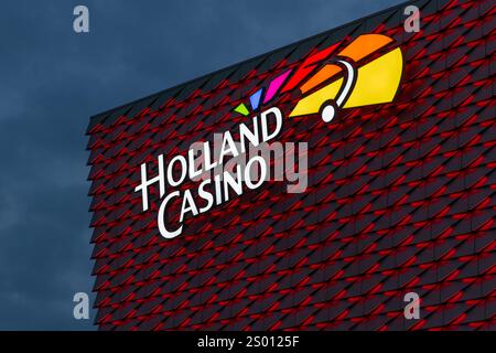 Utrecht, Niederlande. 25. september 2024. Beleuchtetes Holland Casino-Logo auf einem modernen, rot beleuchteten Gebäude. Stockfoto