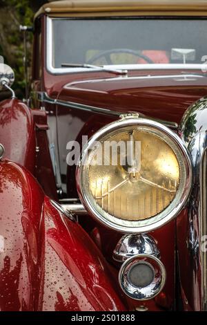 Lissabon, Portugal - 15. Oktober 2023: Nahaufnahme des Scheinwerfers und des vorderen Kotflügels der Lagonda LG45 in Vintage-Rot im selektiven Fokus. Zweitüriger Luxuswagen der Tourenklasse, Stockfoto