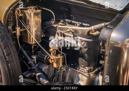 Lissabon, Portugal - 29. September 2024: Nahaufnahme des Motors des 1923er Minerva 20HP Torpedowagens an sonnigem Tag, mit Motorkomponenten der alten Schule und feiner Handwerkskunst, Vergasern und polierten Oberflächen, klassischer Automobiltechnik. Stockfoto