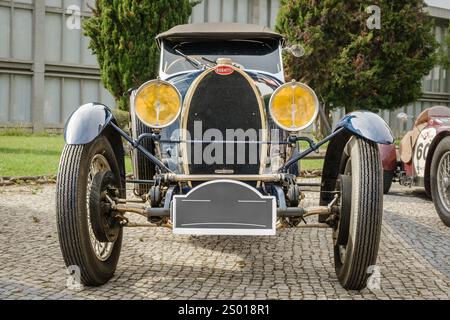 Lissabon, Portugal - 15. Oktober 2023: Vorderansicht des originalen, dunkelblau lackierten Bugatti Type 40 Grand Sport Car, der in der Einfahrt geparkt ist. Grand Tourer Car oder Roadster, 1930er Jahre, von Bugatti, Frankreich. Große Scheinwerfer, offene Räder, einzigartiger Kühlergrill, Kühler, Leinwandhaube Stockfoto