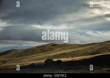 Wunderschöne Landschaft mit grünen Hügeln im Bergtal und grüner saftiger Wiese bei dunklem Sturm, bewölktem Himmel und Regen in Almaty, Kasachstan Stockfoto