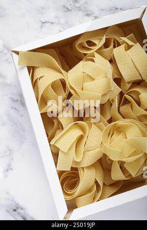 Rohe Pappardelle Nudeln, Nudelnester, in einem Papierkarton, Draufsicht, keine Leute Stockfoto