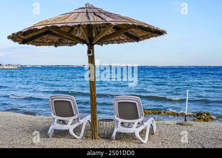 Leeres Strandcafé ohne Besucher nach Ende der Saison, Schilfsonnenschirme, leere Liegen, Adria, Kroatien Stockfoto