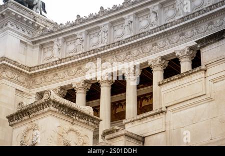 Aus nächster Nähe sehen Sie kunstvolle architektonische Details mit klassischen Säulen, komplizierten Schnitzereien und dekorativen Friesen auf einem historischen Gebäude. Stockfoto