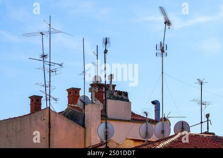 Viele Antennen für den digitalen Fernsehempfang und Satellitenschüsseln sind auf dem Dach des Hauses installiert, Antennen für den Heimfernsehempfang auf dem Dach montiert Stockfoto