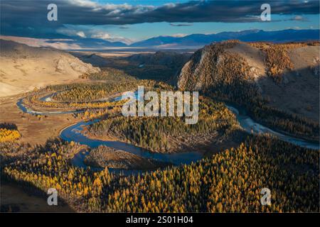 Panoramablick auf einen Fluss, der bei schönem Herbstwetter durch einen farbenfrohen Herbstwald in den Bergen fließt. Stockfoto