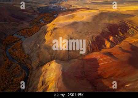 Lebendige rote und orangene Berge mit einem sich windenden Fluss, der von oben in Russland gefangen wurde. Stockfoto