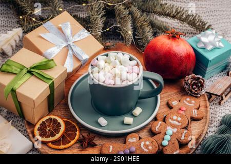 Flacher heißer Kakao mit Marshmallows umgeben von Weihnachtsgeschenken, Lebkuchenkeksen und festlicher Dekoration. Draufsicht. Stockfoto