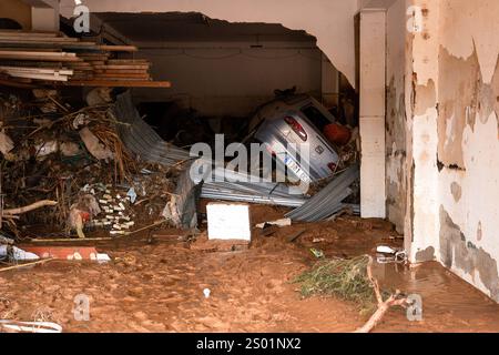 DANA-Flutungseffekte. Überschwemmungseinflüsse, Valencia, Spanien. Nach der Flut hat man Auto und Trümmer in einer Garage in Paiporta umgeworfen. Stockfoto