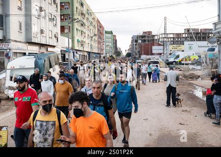 DANA-Flutungseffekte. Überschwemmungseinflüsse, Valencia, Spanien. Freiwillige und Einheimische laufen in schlammigen Straßen Stockfoto